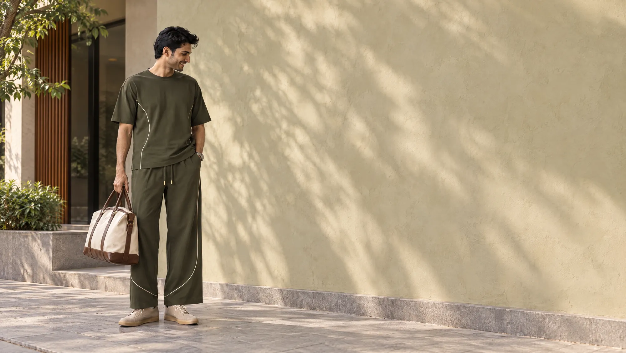 A man in an olive tee and wide-leg pants.